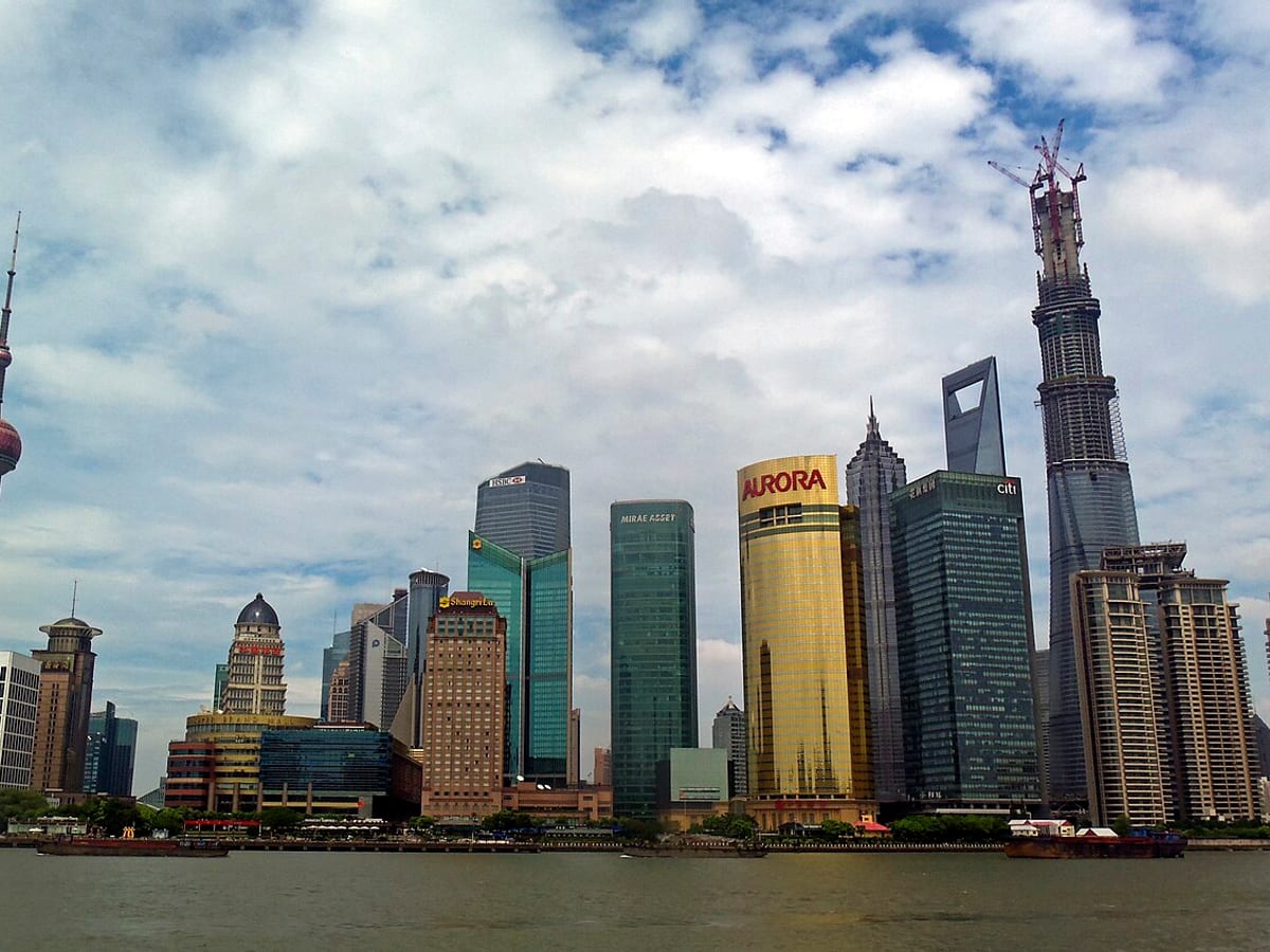 Oriental Pearl Tower and Lujiazui skyscrapers lit at night in Shanghai.