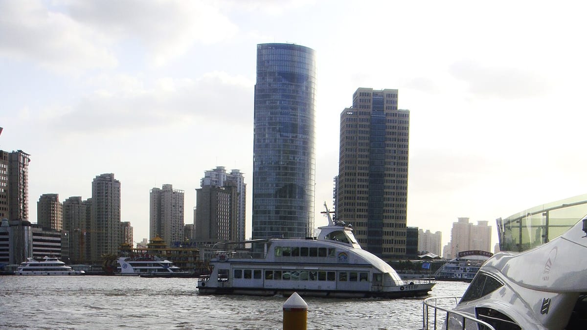 A Shanghai ferry crossing the Huangpu River with Lujiazui towers in the background.